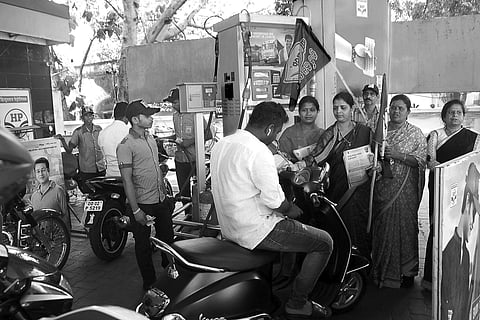 BJD activists distributing leaflets against fuel price hike to commuters at a petrol pump in Bhubaneswar on Saturday | Express
