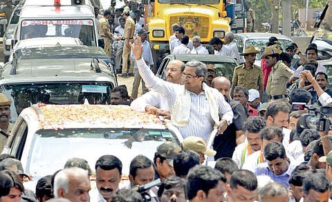 Siddaramaiah at a roadshow in Chamundeshwari recently. The Chief Minister has decided to shift to this constituency  vacating the neighbouring Varuna constituency for his son Yathindra (in the background)