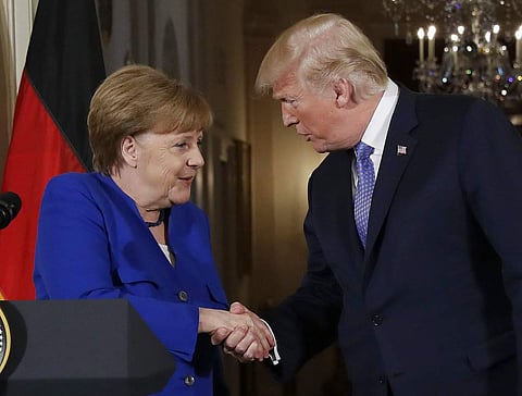 President Donald Trump shakes hands with German Chancellor Angela Merkel during a news conference in the East Room of the White House. | AP