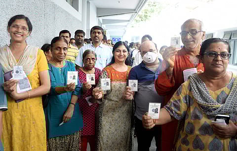 Voters show their Election Commission IDs before they cast their ballot during the polling day for the Karnataka Assembly election 2018 in Bengaluru on Saturday. | PTI