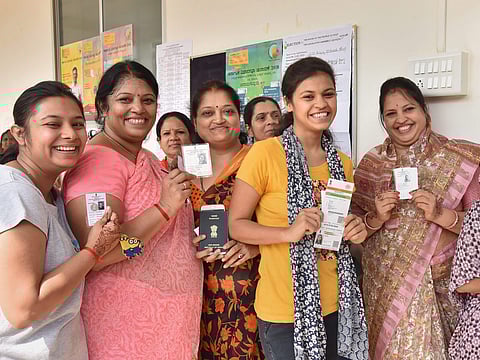 Hubballi Voters show their voting ID as they cast their vote for Karnataka Assembly elections in Hubballi on Saturday. | Express photo