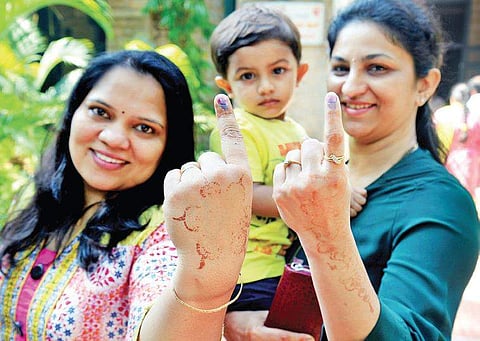 Two friends show off their inked fingers;