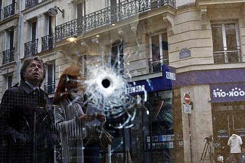 A bullet hole seen on the window of a cafe located near the area where the assailant of a knife attack was shot dead by police officers, in central Paris, Sunday May 13, 2018. (AP Photo)