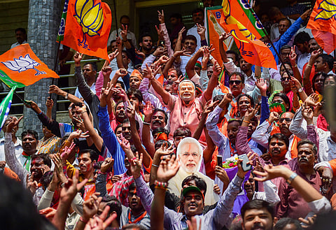 BJP workers dance to celebrate the party's lead on more than 110 Assembly seats as the counting of votes is in progress outside the party office in Bengaluru on Tuesday, 15 May 2018. | PTI