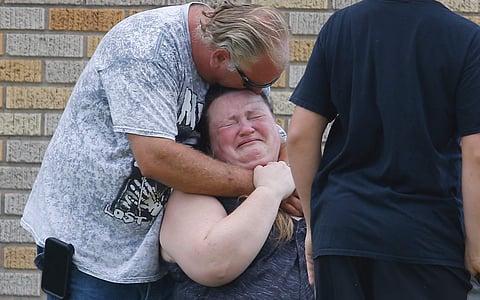 A man hugs a woman outside the Alamo Gym where parents wait to reunite with their children following a shooting at Santa Fe High School in Santa Fe, Texas, on Friday, May 18, 2018. (AP Photo)
