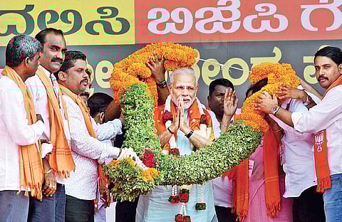 Prime Minister Narendra Modi being greeted by BJP members in Udupi on Tuesday
