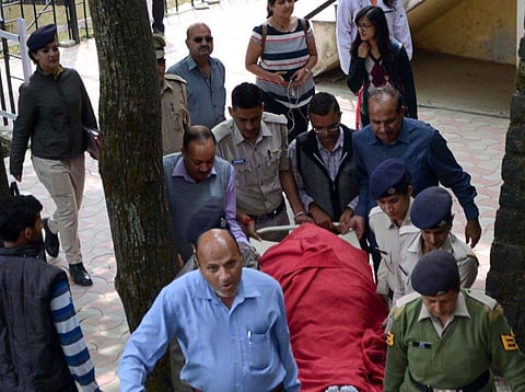 Police personnel carry the body of assistant town and country planning officer Shail Bala Sharma for the postpartum at IGMC hospital in Shimla on Wednesday. | PTI