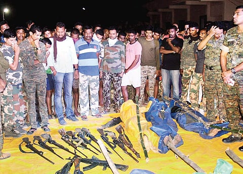 Security personnel display weapons recovered from the Maoists killed in the Gadchiroli encounter in Maharashtra on April 22. | PTI