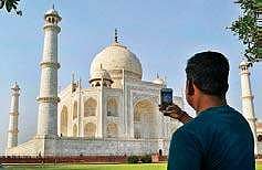 A tourist clicks a picture of Taj Mahal on Tuesday | pti