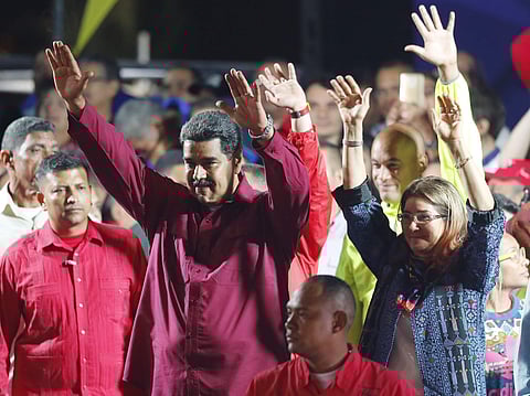 Venezuela's President Nicolas Maduro and his wife Cilia Flores wave to supporters at the presidential palace in Caracas, Venezuela, Sunday, May 20, 2018. | AP