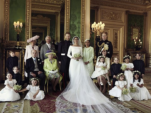 In this photo released by Kensington Palace on Monday May 21, 2018, shows an official wedding photo of Britain's Prince Harry and Meghan Markle, center, in Windsor Castle, Windsor, England, Saturday May 19, 2018. | Associated Press
