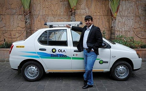 Bhavish Aggarwal, CEO and co-founder of Ola, an app-based cab service provider, poses in front of an Ola cab (File Photo | Reuters)