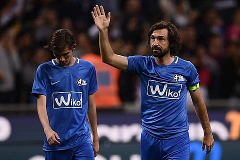 Former Italian football player Andrea Pirlo (R), flanked by his son Niccolo, waves at the end of the 'Notte del Maestro' (master's night), a football match celebrating the end of his career as a football player, on May 21, 2018 at the Giuseppe Meazza Stad