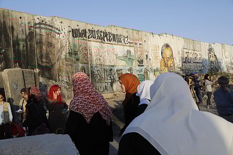 Palestinian women make their way to attend the first Friday prayers in Jerusalem's al-Aqsa mosque during the Muslim holy month of Ramadan, at the Qalandia checkpoint, between the West Bank city of Ramallah and Jerusalem, Friday, May 18, 2018. (AP Photo/Na