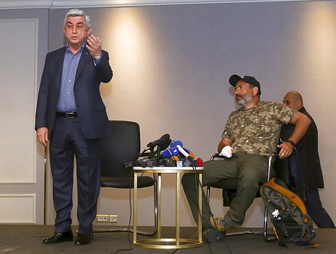 Armenian PM Serzh Sarkisian, left, gestures as he leaves a meeting with protest leader Nikol Pashinyan, right, in Yerevan. (AP)