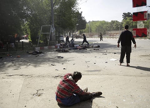 A wounded man sits on the ground after explosions, in Afghanistan. (Photo | AP)