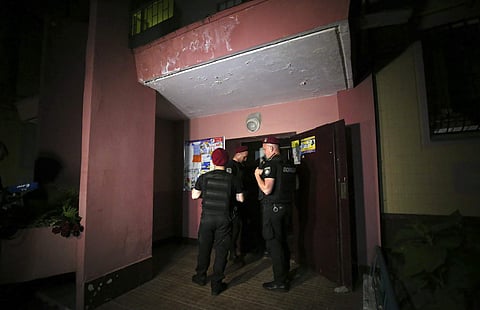 Police guard the front door of the multi-storey building where Russian opposition journalist Arkady Babchenko lived, in Kiev, Ukraine, Tuesday, May 29, 2018. | AP