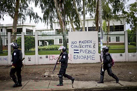 A massive march in Nicaragua against President Daniel Ortega's government ended in violence Wednesday after gunmen opened fire on marchers. IN PIC: Riot police walk in front a wall with graffiti that reads in Spanish 'You can't against this giant nation',