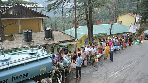Residents queue up to collect drinking water from a tanker in Shimla. | PTI
