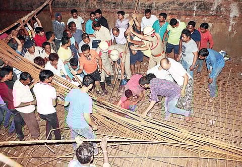 Locals rescuing a worker trapped under the iron frame which collapsed at the under-construction Bomikhal flyover site in Bhubaneswar on Thursday | irfana