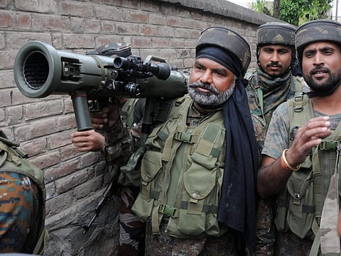 Army soliders carrying rocket launcher as they moves outside the house held up by militants during an encounter in Srinagar on Saturday. | PTI