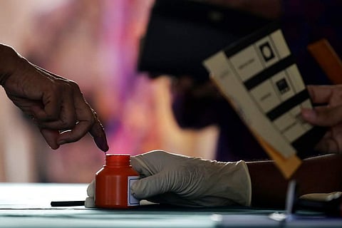 A man gets his finger marked with ink before casting his ballot at a voting center during the general elections in Alor Setar, state capital of Kedah, northern Malaysia. | AP