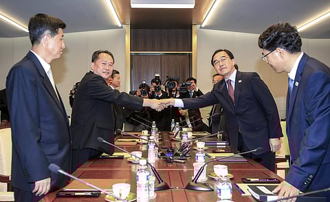South Korean Unification Minister Cho Myoung-gyon, second from right, shakes hands with the head of North Korean delegation Ri Son Gwon during their meeting inside the Peace House at the southern side of Panmunjom in the Demilitarized Zone, South Korea, F