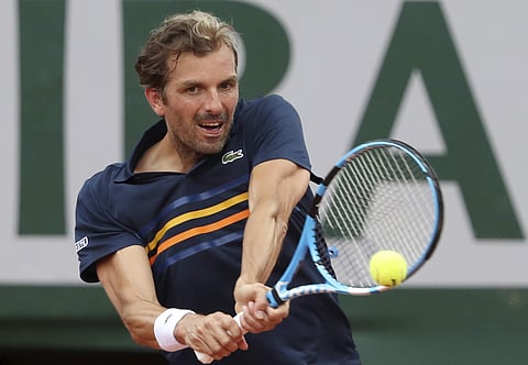 Julien Benneteau returns a shot against Juan Martin del Potro during their second round match of the French Open tournament at the Roland Garros stadium in Paris. | AP