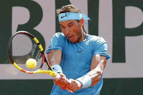 Rafael Nadal returns the ball to Guido Pella during their second round match of the French Open tournament at the Roland Garros stadium. | AP