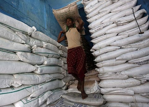 A labourer carries a sack filled with sugar in a store at a wholesale market in Kolkata, India, February 15, 2016. | Reuters
