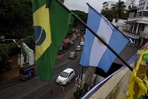 Flags of Brazil and Argentina erected by Indian soccer enthusiasts are seen atop a roadside building in Kerala | AP