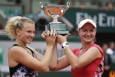 Barbora Krejcikova, right, and Katerina Siniakova, left, of the Czech Republic hold the trophy as they celebrate winning the women's doubles final match of the French Open tennis tournament against Japan's Eri Hoizumi and Makoto Ninomiya in two sets 6-3, 