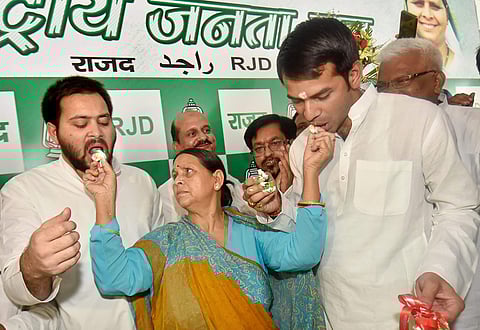 Former Bihar CM Rabri Devi shares cake with her sons Tejaswi Yadav and Tej Partap Yadav while celebrating her husband RJD chief Lalu Prasad Yadav's 71st birthday in Patna on une 11, 2018. (PTI Photo)