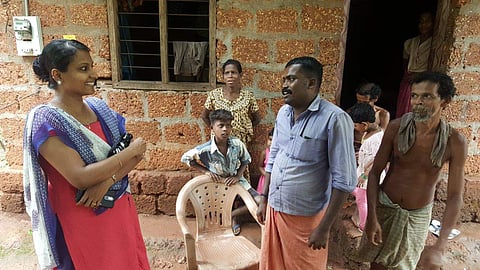 The Good Doctor: Dr Shinu Syamalan (right) interacting with ooru moopan Ratheesh V R and other residents of Kadayakara colony at Kadumeni in West Eleri panchayat. (Express Photo)