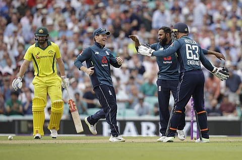 England's Adil Rashid, second right, celebrates taking the wicket of Australia's Ashton Agar, not pictured, with England captain Eoin Morgan, second left, and wicketkeeper Jos Buttler during the one-day cricket match between England and Australia at the O
