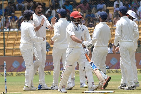 Indian cricketer Ishant Sharma with teammates celebrates the wicket of Afghanistan batsman Afsar Zazai  during the second day of a one-off test match at M Chinnaswamy Stadium in Bengaluru on Friday. ( EPS | Vinodkumar T )