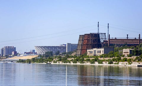 The Red October factory buildings, right, are seen next to the new the World Cup stadium, left, on the banks of the Volga River in Volgograd, Russia. | AP