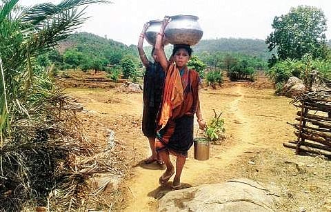 Women carrying water from a nullah in Sudra village of Kandhamal district | Express