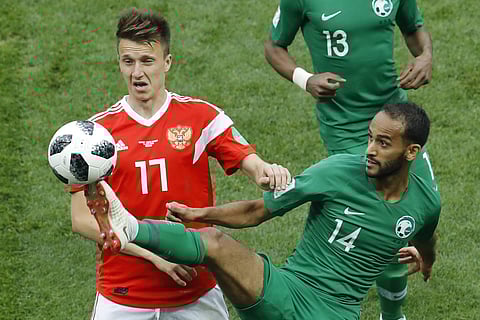 Russia's Roman Zobnin, left, and Saudi Arabia's Abdullah Otayf vie for the ball during the group A match between Russia and Saudi Arabia which opens the 2018 soccer World Cup at the Luzhniki stadium in Moscow. | AP