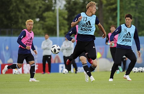 Japan's Keisuke Honda, left, and Hiroki Sakai, right, compete for the ball during a training session. (AP)