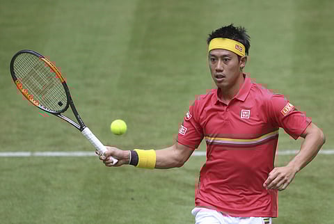 Kei Nishikori returns the ball to Matthias Bachingerl during their match at the ATP tennis tournament in Halle, Germany. (AP)