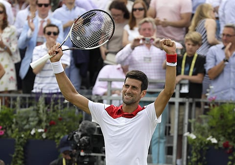 Novak Djokovic of Serbia celebrates winning his singles tennis match against John Millman of Australia at the Queen's Club tennis tournament in London. (AP)