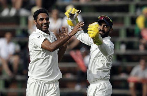 Bhuvneshwar Kumar, left, celebrates with teammate Dinesh Karthik, after dismissing South Africa's batsman Kagiso Rabada, on the fourth day of the third cricket test match at the Wanderers Stadium. (File Photo | AP)