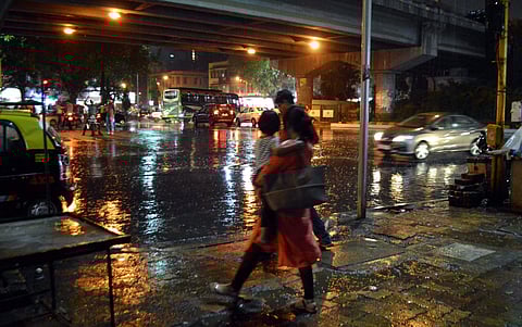 A woman walks during rains in Mumbai on Saturday. (PTI)