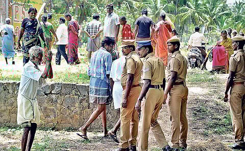 Policemen stand guard even as farmers protest during the second day of survey in Salem | Express