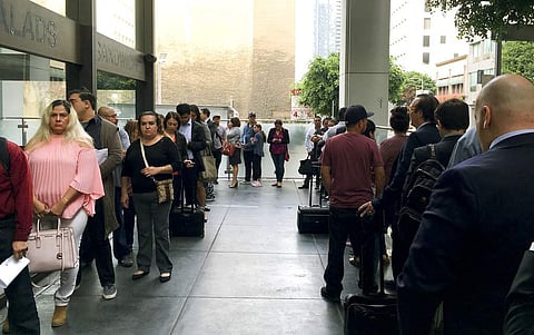 In this Tuesday, June 19, 2018 photo, immigrants awaiting deportation hearings, line up outside the building that houses the immigration courts in Los Angeles. Inside the courtroom, immigrant children who arrived on the U.S. border seeking asylum or other