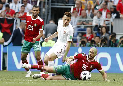 Portugal's Raphael Guerreiro, center, is challenged by Morocco's Noureddine Amrabat, bottom, during the group B match between Portugal and Morocco at the 2018 soccer World Cup at the Luzhniki Stadium in Moscow, Russia, Wednesday, June 20, 2018. | AP