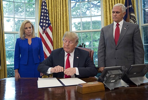 President Donald Trump prepares to sign an executive order to end family separations, during an event in the Oval Office of the White House in Washington, Wednesday, June 20, 2018. | AP