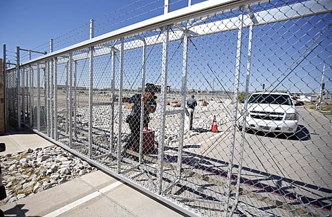 An agent with the Department of Homeland Security closes the exterior gate of the holding facility for immigrant children in Tornillo, Texas, near the Mexican border, Thursday, June 21, 2018. (Photo | AP)