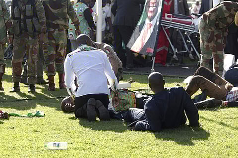 Injured people are attended to as they lay on the ground following an explosion at a Zanu pf rally in Bulawayo (Photo | AP)